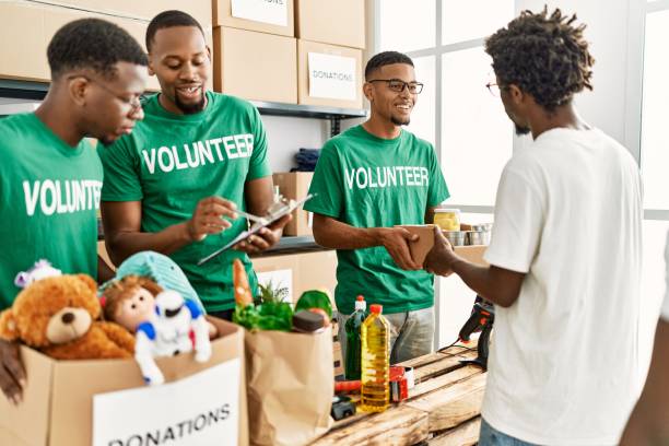 group of young african american volunteers helping people at charity center.